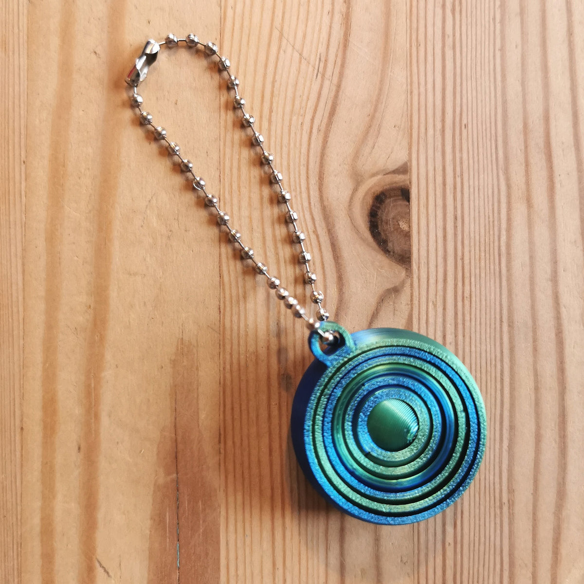 Spiraalifidget avaimenperä liukuvärjätty sinivihreä